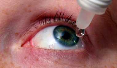 woman putting drops in eyes